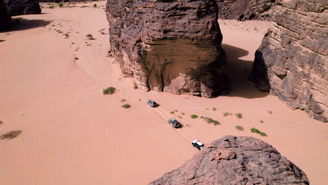 Aerial-View-Of-Cars-Driving-Across-Sahara-Desert-In-Tassili-N'Ajjer-National-Park,-Algeria