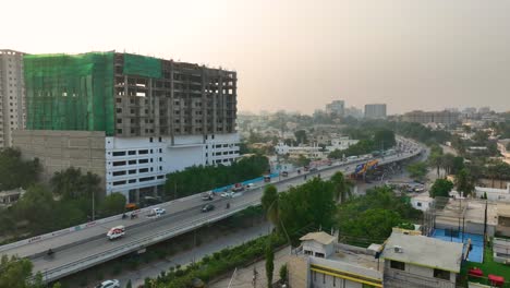 Luftaufnahme-Der-Belebten-Shaheed-e-Millat-Straße,-Umgeben-Von-Gebäuden-Am-Abend-In-Karachi-In-Pakistan