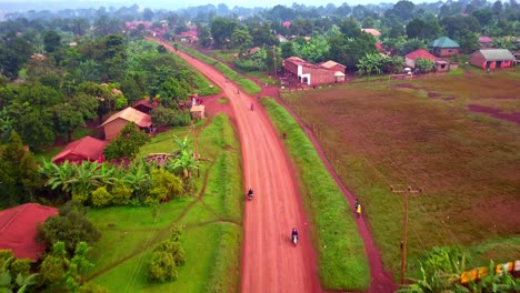 Motocicletas-Conduciendo-Por-Una-Carretera-Rural-En-Uganda,-África---Toma-Aérea