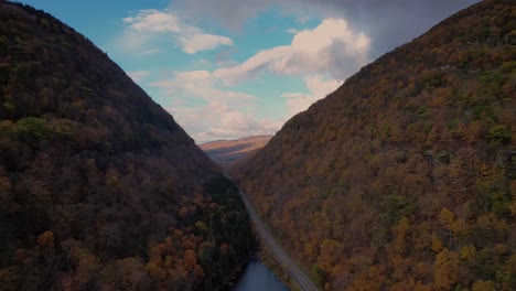 Beautiful-drone-footage-of-a-deep-autumnal-valley-with-beautiful-colors-and-mountain-road