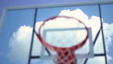 Looking-away-from-unfocused-playground-basketball-hoop-to-big-white-blue-sky-cloud