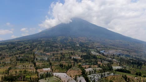 Dry-land-fields-and-mount-Sumbing-in-background-in-Indonesia,-aerial-view