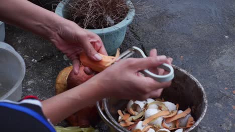 Sweet-potato-skin-removed-by-hand-using-peeler,-filmed-in-outdoor-setting-as-close-up-slow-motion-shot
