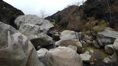 Topanga-Canyon-in-California-with-FPV-drone-video-moving-forward-above-river-and-rocks