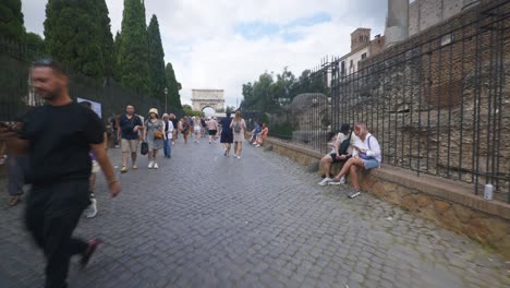 Rome-Immersive-POV:-Moving-In-Busy-Streets-to-Chiesa-Santi-Luca-e-Martina,-Italy,-Europe,-Walking,-Shaky,-4K-|-Large-Crowds-on-Slim-Brick-Road