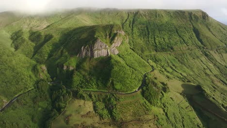 Aerial-view-of-Rocha-dos-Bordões-with-white-car-driving-on-road,-Azores