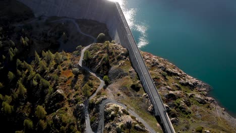 Aerial-flyover-over-the-hydroelectric-dam-of-Lac-de-Salanfe-in-Valais,-Switzerland-on-a-sunny-autumn-day-in-the-Swiss-Alps-in-a-remote-alpine-location