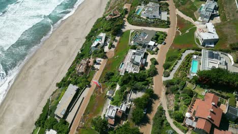 Gleitschirmflug-über-Häuser-Am-Meer-An-Der-Küste-Chiles