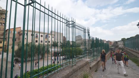 Rome-Immersive-POV:-Moving-In-Busy-Streets-to-Chiesa-Santi-Luca-e-Martina,-Italy,-Europe,-Walking,-Shaky,-4K-|-Wide-Shot-of-Ruins-Near-Fence