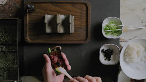 Von-Oben-Nach-Unten-Aufnahme-Eines-Kochs,-Der-Eine-Sushi-Handrolle-Zubereitet