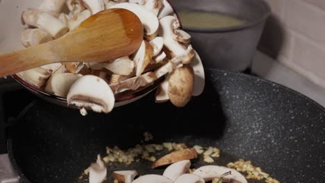 Pouring-Sliced-And-Chopped-Mushrooms-Into-Frying-Pan---Close-Up