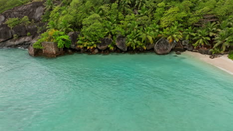 Luftaufnahme-Eines-Kleinen-Exotischen-Strandes,-Umgeben-Von-Grüner,-üppiger-Vegetation-Auf-Den-Seychellen