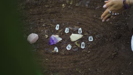 Close-up-of-a-person's-hand-meditating-with-crystal-rocks-on-the-river-bank-in-the-Salto-Encantado-park-located-in-Misiones,-Argentina
