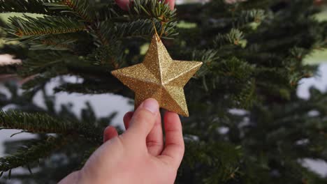 Hanging-Golden-Star-On-Green-Christmas-Tree-Close-Up-4K