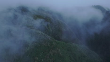 Kuh-Weidet-Auf-Einem-Steilen-Hügel-Mit-Niedrigen-Wolken-Auf-Den-Azoren,-Luftaufnahme