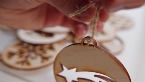 Threading-Natural-String-Through-Wooden-Christmas-Decoration