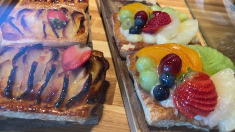 Assorted-fruit-tarts-on-a-wooden-board,-ready-to-serve
