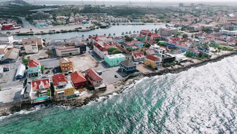 The-drone-is-flying-above-the-sea-looking-at-Pietermaai-street-in-Willemstad-Curacao-Aerial-Footage-4K