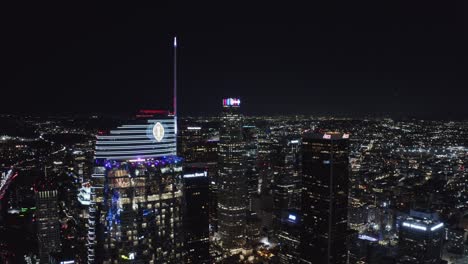 Innenstadt-Von-Los-Angeles-Bei-Nacht,-Flug-über-Wolkenkratzern-Und-Türmen-Von-Unternehmen-Und-Glänzenden-Lichtern