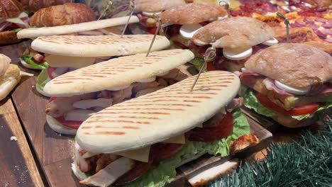 Gegrillte-Sandwiches-Und-Subs-Mit-Verschiedenen-Belägen-Auf-Einem-Holzbrett