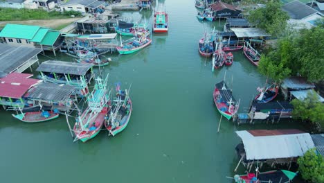 Drone-pointing-its-camera-down-as-it-reveals-fishing-boats-parked-in-Bang-Pu-Fishing-Village,-Sam-Roi-Yot-National-Park,-Prachuap-Khiri-Khan,-Thailand