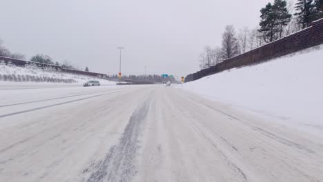 The-car-skillfully-negotiates-difficult-winter-conditions-on-the-highway,-smoothly-navigating-snowy-terrain-at-high-speed