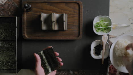 Von-Oben-Nach-Unten-Aufnahme-Eines-Kochs,-Der-Sushi-Handrollen-Zubereitet