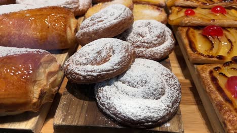 Freshly-baked-pastries-with-powdered-sugar-on-a-wooden-surface