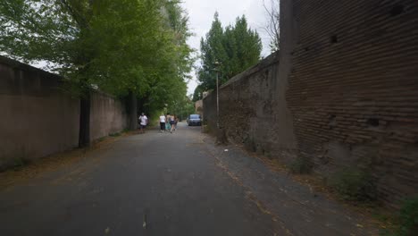 Punto-De-Vista-Inmersivo-En-Roma:-Moverse-Por-Calles-Concurridas-Hasta-Chiesa-Santi-Luca-E-Martina,-Italia,-Europa,-Caminar,-Tembloroso,-4k-|-Turistas-Caminando-Por-Un-Camino-Oscuro
