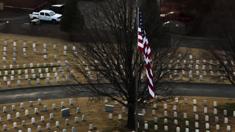 Toma-Aérea-En-órbita-De-La-Bandera-Estadounidense-En-El-Cementerio-Nacional-De-Fayetteville-En-Arkansas