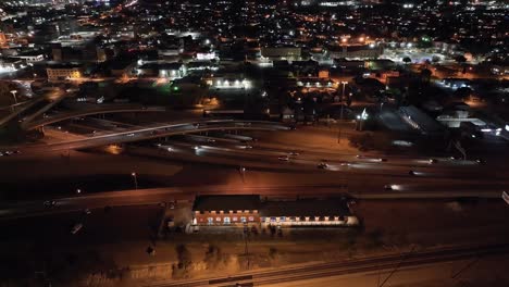 Freeway-in-El-Paso,-Texas-at-night-with-traffic-moving-and-stable-drone-video