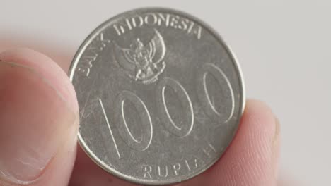 Hält-Zwischen-Den-Fingern-Eine-1000-Indonesische-Rupiah-Münze