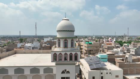 Beautiful-aerial-shot-of-Darul-Uloom-Hussainia-Shahdadpur-in-between-a-city-during-a-sunny-day-in-Sindh,-Pakistan