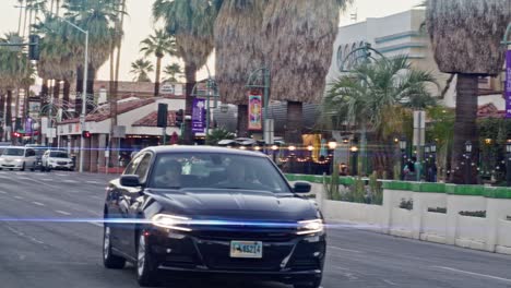 Car-driving-in-downtown-Palm-Springs,-California-in-slow-motion-with-lens-flare-effect