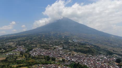 Small-township-and-massive-mount-Sumbing-in-background,-aerial-drone-view