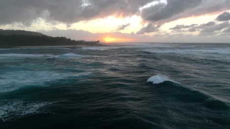 Eine-Luftperspektive-Während-Der-Goldenen-Stunde-Fängt-Den-Spektakulären-Anblick-Großer-Wellen-Ein,-Die-Sich-Bei-Sonnenuntergang-Vor-Der-Meereskulisse-Brechen