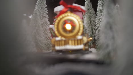 Vintage-toy-locomotive-riding-through-snowy-forest-and-snowfall