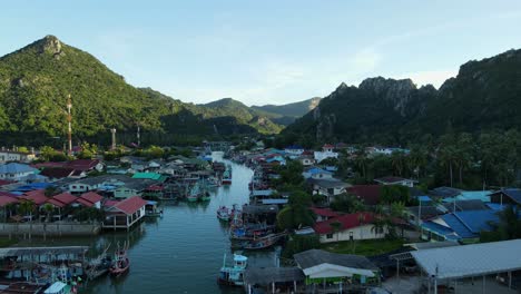 Moving-backwards-the-drone-reveals-a-fishing-community,-Bang-Pu-Fishing-Village,-Sam-Roi-Yot-National-Park,-Prachuap-Khiri-Khan,-Thailand