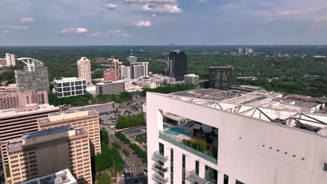 Drone-shot-revealing-big-parking-lot-of-Buckhead-city-of-Atlanta-neighbourhood,-modern-skyline-buildings,-Georgia,-USA