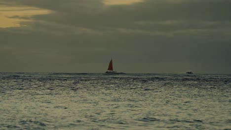 Kurz-Nach-Sonnenuntergang-Ziert-Ein-Segelboot-Den-Horizont-Des-Riesigen-Ozeans-Mit-Einem-Goldenen-Himmel