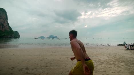 footage-of-a-man-model-running-on-Railay-beach-in-Krabi-Thailand-footage-of-incredible-Thai-landscapes-incredible-nature-with-insane-rocks,-jungle,-ocean,-sea