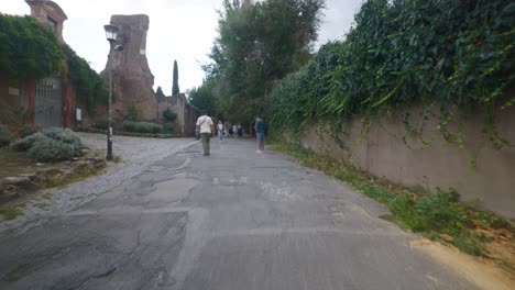 Punto-De-Vista-Inmersivo-En-Roma:-Moverse-Por-Calles-Concurridas-Hasta-Chiesa-Santi-Luca-E-Martina,-Italia,-Europa,-Caminar,-Tembloroso,-4k-|-Viajeros-Caminando-Por-La-Carretera-Cerca-De-Ruinas
