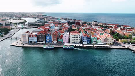 Die-Drohne-Fliegt-Um-Die-Alten,-Farbenfrohen-Häuser-Am-Handelskai-In-Willemstad,-Curaçao,-Luftaufnahmen-In-4K