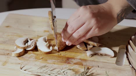 Hands-Cut-A-Mushroom-On-The-Wooden-Cutting-Board---Close-Up
