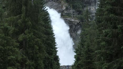 Surrounded-by-alpine-trees,-cascading-waterfall-showcases-beauty-of-Austria