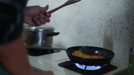 Hot-fry-pan-with-fried-egg-placed-on-blue-gas-flame-stove,-filmed-as-medium-close-up-shot-in-slow-motion
