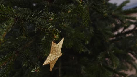 Hanging-Golden-Star-On-Green-Christmas-Tree-4K