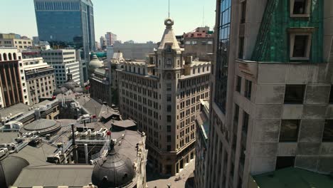 Flyover-establishing-over-La-Bolsa-neighborhood-with-the-Ariztía-Building-on-a-sunny-day-in-the-financial-center-of-Santiago-Chile