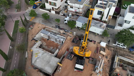 Heavy-crane-in-construction-site-of-modular-home,-aerial-view