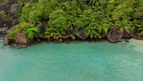 Vista-Aérea-De-Una-Pequeña-Playa-Exótica-Rodeada-De-Exuberante-Vegetación-Verde-En-Las-Seychelles.